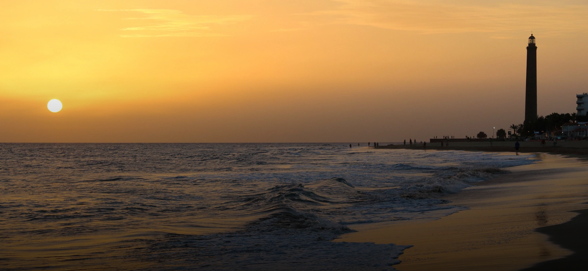 Sunset over the ocean with the Maspalomas Lighthouse silhouetted on the coast of Gran Canaria, near Sport Hotel Monte Feliz