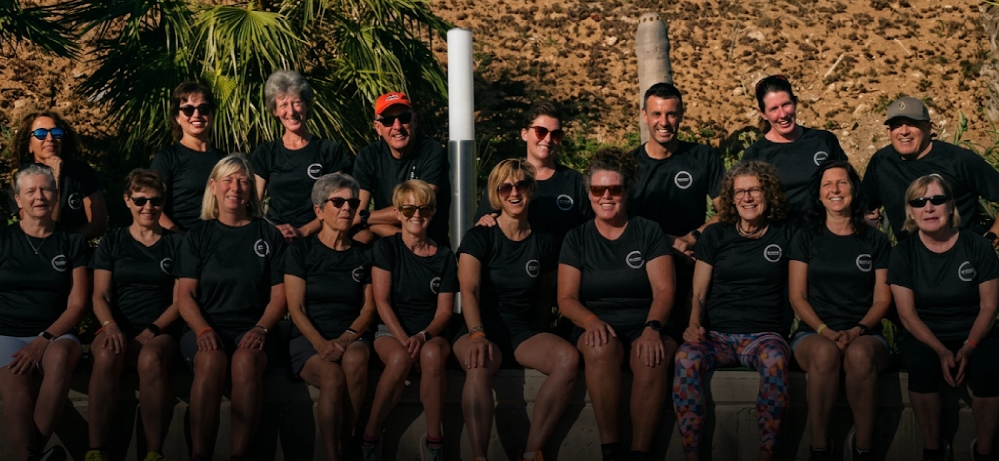 Group of Total Fitness Week participants in matching black t-shirts posing together outdoors